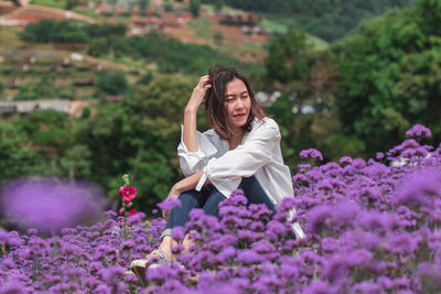 Woman standing on purple flowering plants