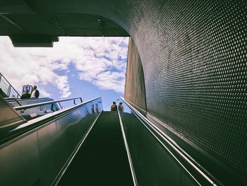 Low angle view of escalator against sky