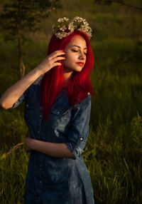 Redhead young woman wearing flowers standing on field