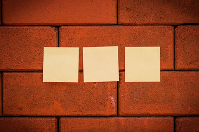 Blank yellow notes on brick wall