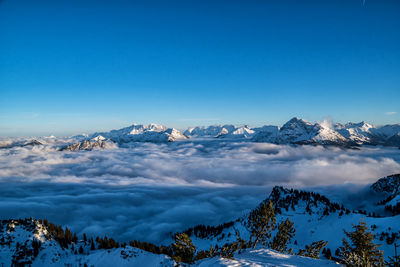 Scenic view of snowcapped mountains against blue sky