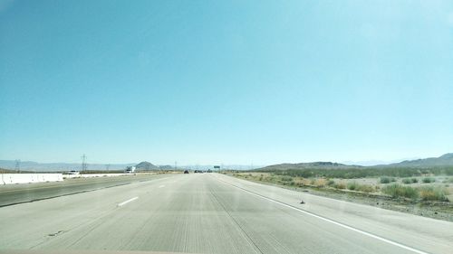 Road against clear blue sky