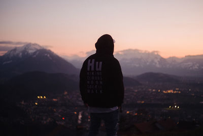 Rear view of silhouette man looking at mountains against sky