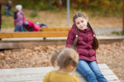 Rear view of girl sitting on bench