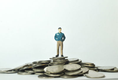 Close-up of figurine of coin against white background