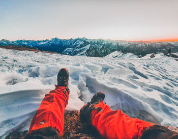 Person on snowcapped mountain against sky