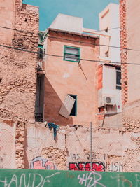 Low angle view of clothes drying on wall of building