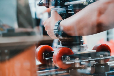 Cropped hand of man repairing machinery