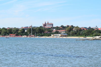 Scenic view of sea by buildings against sky