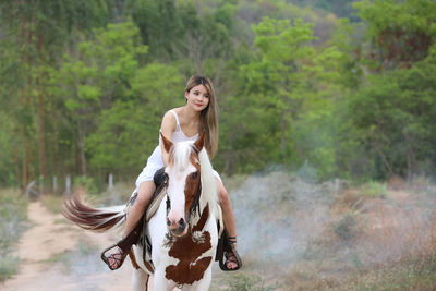 Portrait of young woman riding horse