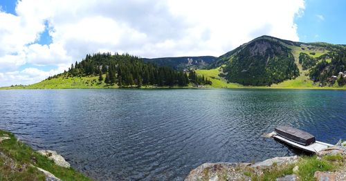 Scenic view of lake by mountains against sky