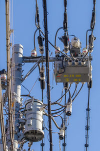 Low angle view of electricity pylon against sky