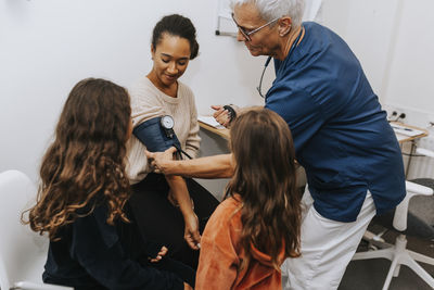 Doctor checking womans blood pressure