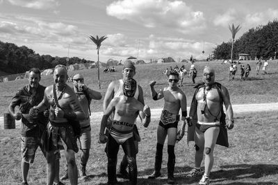 People standing on field against sky