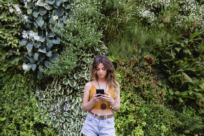 Smiling woman standing by plants