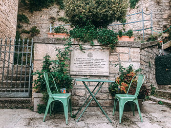 Empty chairs and tables against building