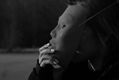 Close-up of woman wearing mask standing outdoors