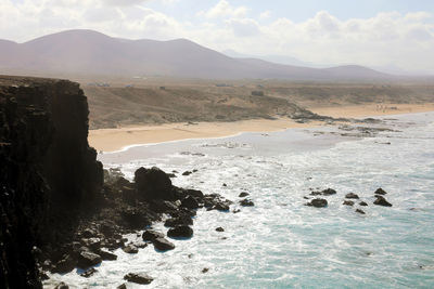 Scenic view of sea and mountains against sky