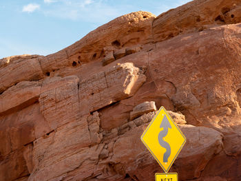 Low angle view of sign on rock
