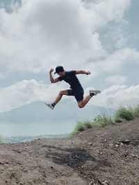 Full length of man jumping against sky