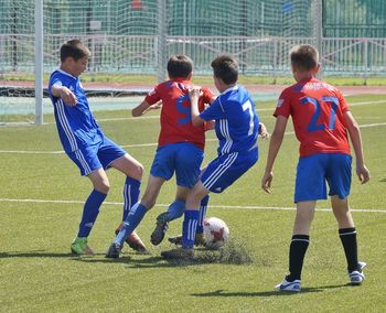 Group of people playing soccer on field