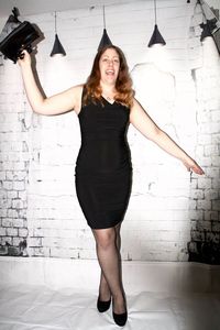 Portrait of young woman standing against wall