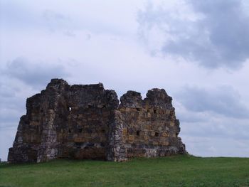 Old ruins on field against sky