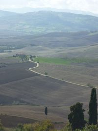 High angle view of road amidst field against sky