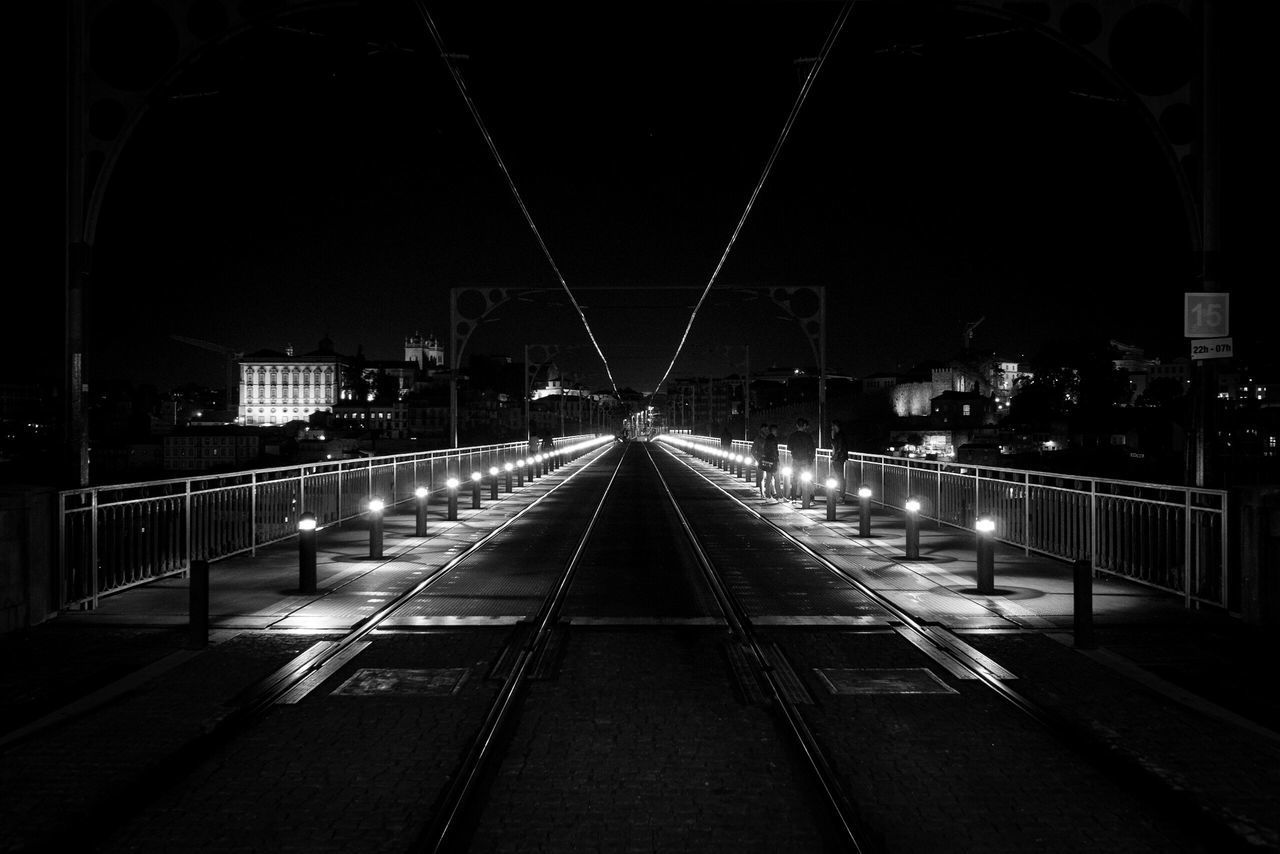 ILLUMINATED RAILROAD TRACKS IN CITY AGAINST CLEAR SKY