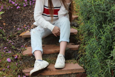 Low section of woman sitting on flower