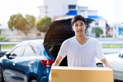 Portrait of man standing in car