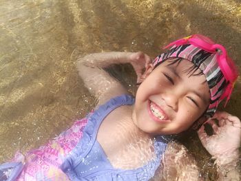 Close-up portrait of smiling girl in water