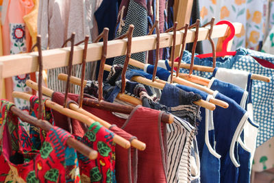 Clothes racks with cotton colorful ethnic dresses on wooden hangers. clothes on local street market.