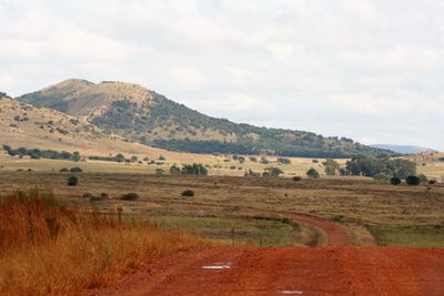 Scenic view of field and mountains against sky