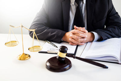Midsection of man reading book on table