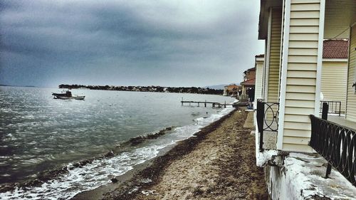 Pier on sea against cloudy sky