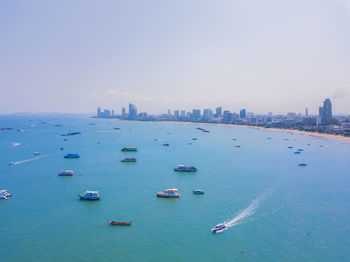 Boats in sea against buildings in city