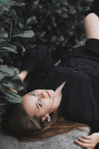 Portrait of woman lying on land by plants