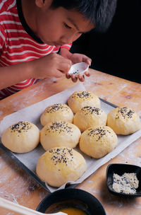 High angle view of boy making buns