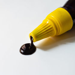 Close-up of yellow light bulb over white background