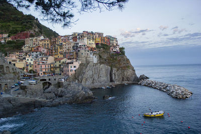 Scenic view of sea by buildings against sky