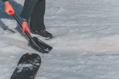 Low section of man skiing on snow covered field