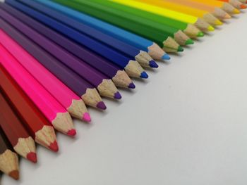 Close-up of colored pencils over white background