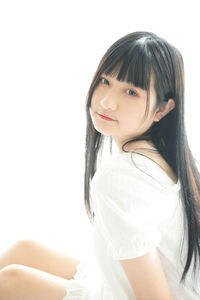 Portrait of young woman against white background