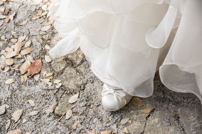 Low section of bride standing outdoors