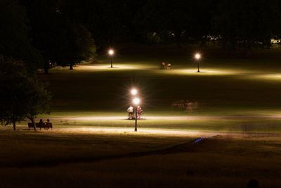 People walking on illuminated street at night