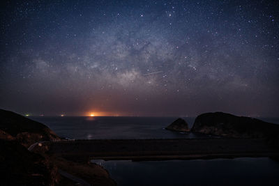 Scenic view of lake against sky at night