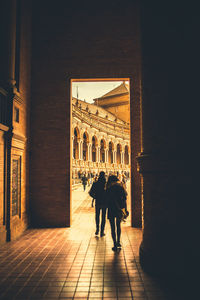 People walking in corridor of historical building