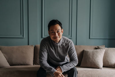 Young man sitting on sofa at home