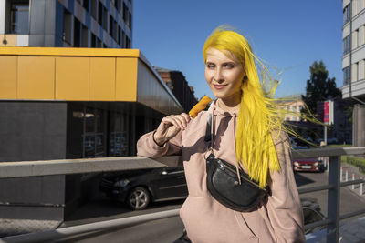 Portrait of smiling young woman in city